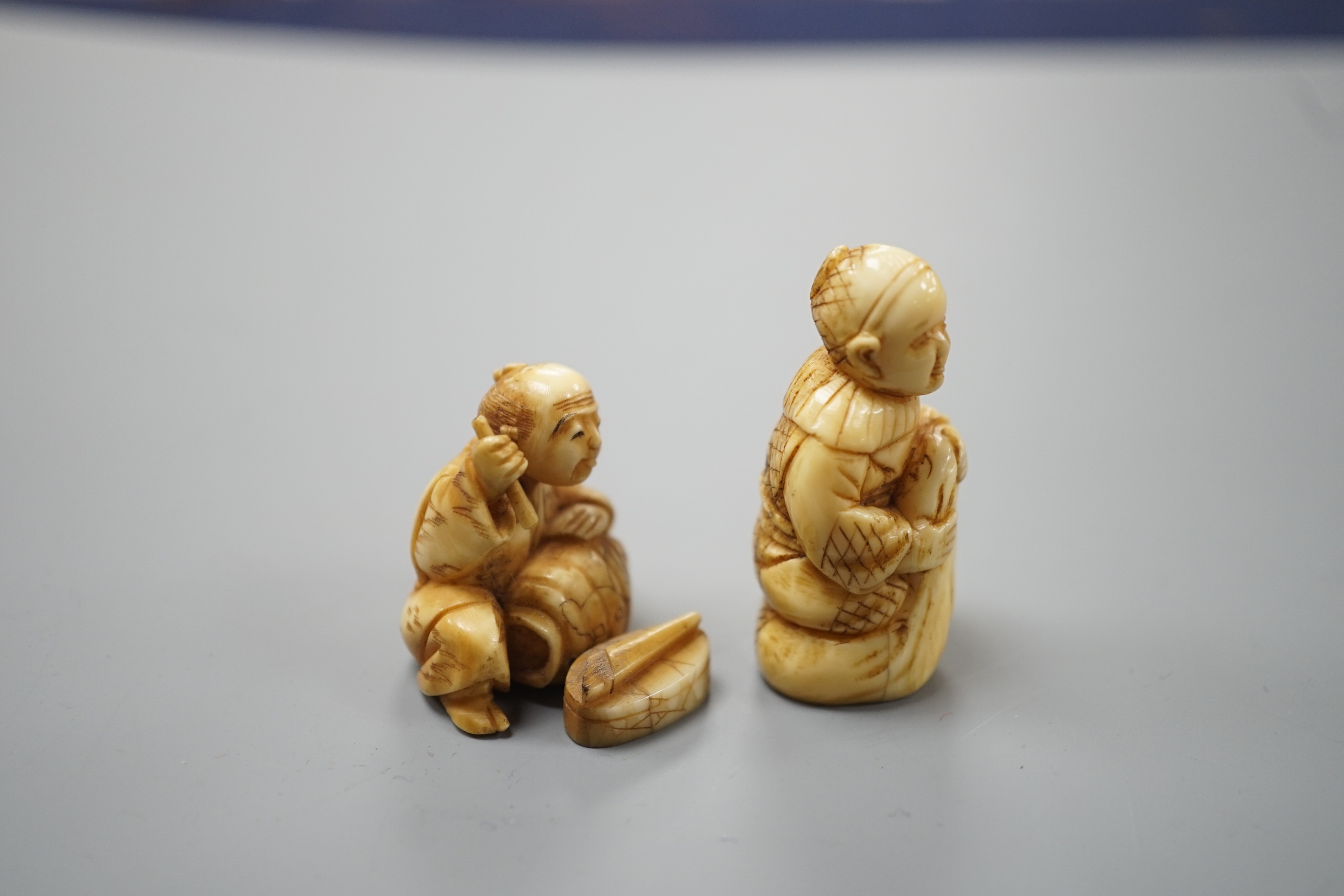 Two Japanese ivory netsuke of craftsman or street vendors, early 20th century, tallest 4.3cm